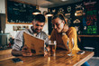 © cherryandbees - couple ordering food looking at menu in food corner bar