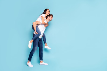 Poster - Full length body size profile side view of nice attractive lovely cheerful people piggybacking having fun free time isolated on bright vivid shine vibrant blue turquoise background