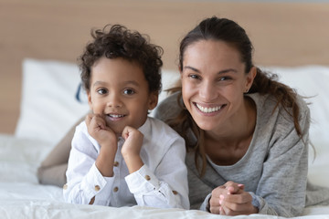 Wall Mural - Portrait of smiling young mom posing with biracial son