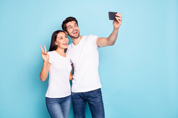 Poster - Portrait of his he her she nice attractive lovely funny glad excited cheerful cheery couple hugging making selfie showing v-sign isolated on bright vivid shine vibrant blue turquoise background