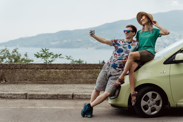 Travelers couple taking selfie with smart phone. Young man and woman taking self portrait while vacation