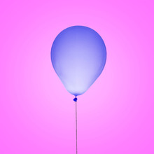 Bright Purple Blue Ball Isolated On Pink Background. Flies Because The Inflated With Helium. Beautiful Color Of The Balloon. Festive Mood. Strong Thread Does Not Allow It To Fly Away, You Can Tie