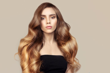 portrait of a beautiful young brunette woman with long wavy hair. shiny thick hair