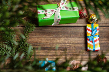 Wall Mural - Colorful gift boxes cookies, fir, spruce, branches on a dark wooden background close up. The concept of preparing for the holidays New Year and Christmas.