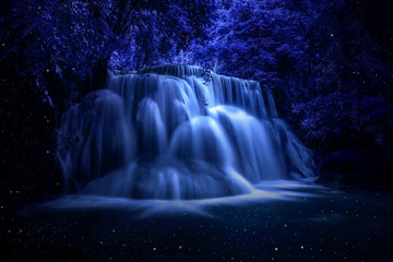 Beautiful waterfall nature scenery of colorful at a night deep tropical fantasy jungle