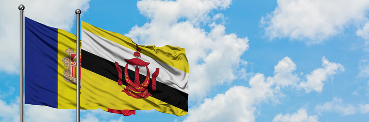 Andorra and Brunei flag waving in the wind against white cloudy blue sky together. Diplomacy concept, international relations.