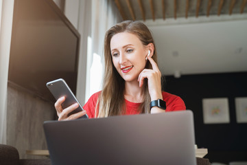 Wall Mural - Woman listening to audio book in earphones using app on smartphone. Interesting videos and text content online for mobile users. Tools and options in web for social media users and network followers.