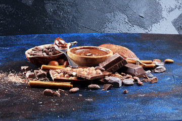 Chocolate bar pieces and melting swirl cocoa. Sweet food photo concept. The chunks of broken chocolate on table