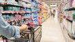 © Yingyaipumi - shopping in a supermarket concept.Shopping in supermarket a shopping cart view with motion blur.Close up of a woman shopping in a supermarket.Customer pushing a shopping cart in a supermarket.