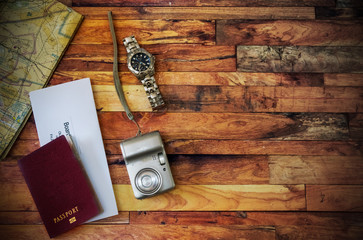 Travel flat lay with passport, camera, map, watch and airline ticket