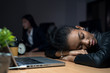 African businesswoman falls asleep because she is tired of working overtime in the office to complete the project within the time limit.