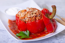 Peppers Stuffed With Meat, Rice And Vegetables With Tomato Sauce And Sour Cream. A Traditional Dish. Close-up.