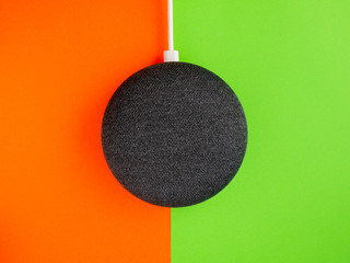 Wall Mural - Smart home device speaker on green and orange background