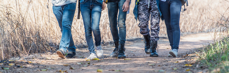 Lifestyle group of people with shoes walking the forest while travelling on vacation.