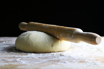 Wall Mural - Pasta fresca pronta per la cottura con un mattarello su tavolo di legno infarinato