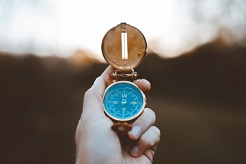 Canvas Print - Closeup shot of a person holding a compass with a burred background