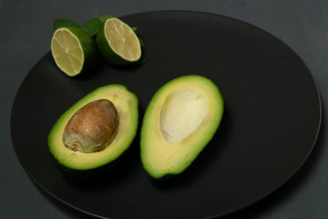 Wall Mural - Avocado with limes on a dark backgroung