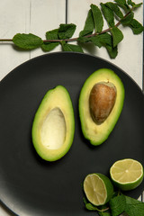 Wall Mural - Avocado with limes on a white wooden backgroung