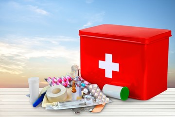 Poster - First aid kit  with medical supplies on light background