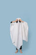 Boy in ghost costume for Halloween on blue background