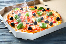 Box With Tasty Italian Pizza On Wooden Table