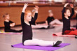 © Evgeniy Kalinovskiy - child preschooler - a cute red-haired girl ballerina stretching and doing the splits on the background of ballet schools and groups of children