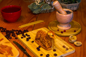 Wall Mural - preparation of treats for traditional Orthodox Christmas - handmade baked cookies in the form of lambkin, dried fruits, cranberries, honey, nuts, rice pudding, mortar with poppy seeds, Church candles