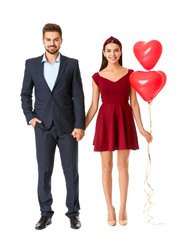 Poster - Portrait of beautiful young couple with air balloons on white background