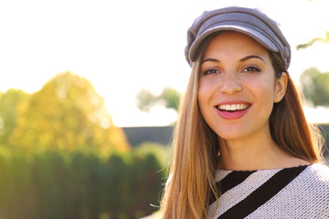 Wall Mural - Close up of young fashion woman with hat in park on autumn season. Looking at camera.