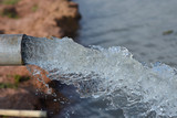 Fototapeta Tęcza - water flow out from pipe by pump supply for dry season
