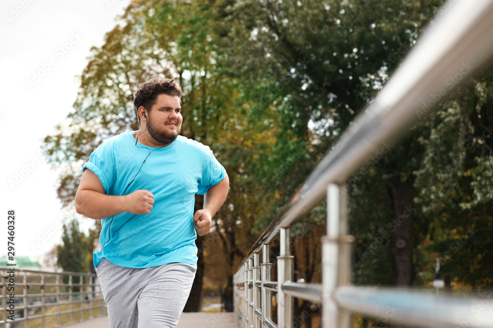 Young overweight man running outdoors. Fitness lifestyle - obrazy, fototapety, plakaty 
