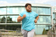 © New Africa - Young overweight man running outdoors. Fitness lifestyle