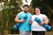 © New Africa - Overweight couple wearing sportswear with mats in park