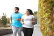 © New Africa - Overweight couple running together in park