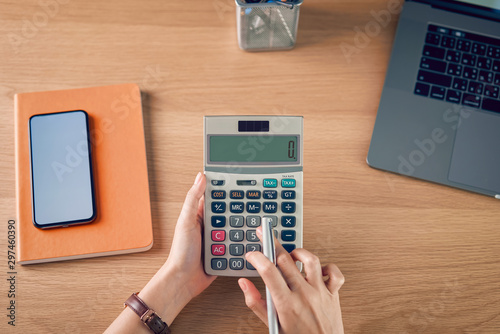 Cuadros en Lienzo Woman holding and press calculator to calculate income expenses and plans for spending money on home office