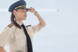 © globalmoments - A female captain pilot standing next to an airplane at the airport.