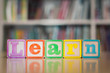 © globalmoments - The word 'learn' with toys and books. Children reading and academics.