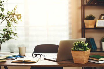 workplace   Desk with   computer at   window in   office at home in   apartment.