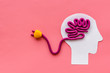 Brain charging and mental rest. Plug and cable leads to plastiline meanders on pink background top view copy space