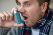© zinkevych - Close up of bearded man feeling scared while using inhalator