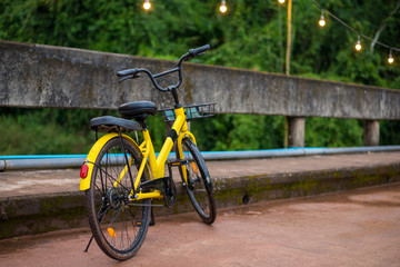 Modern yellow bicycle parked on the bridge. Bicycles make us enjoy holiday activities and exercise.