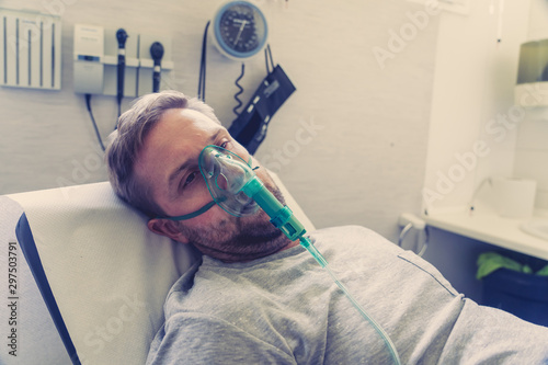 Fotografía Sick man with oxygen mask in emergency room at hospital