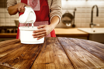 Wall Mural - woman hands in kitchen making cake. Wooden table of free space for your product and christmas time. 