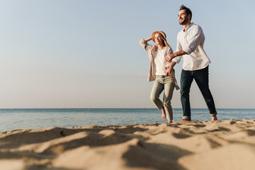 Wall Mural - beautiful happy young couple spending time at the beach