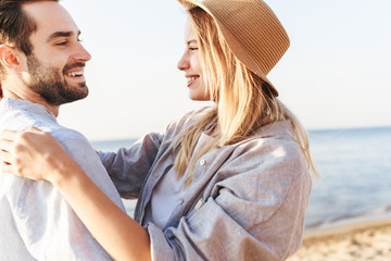 Wall Mural - Beautiful happy young couple spending time at the beach