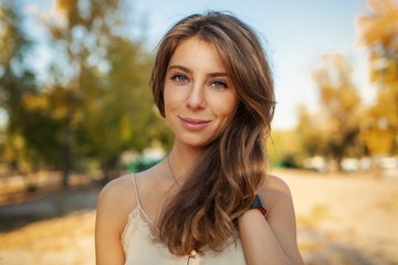 Portrait of a beautiful girl on a background of autumn landscape