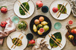 Fall or Autumn table setting for holiday dinner. Flat-lay of dinnerware with fruit and fallen leaves for decoration over linen tablecloth, top view. Preparation for Thanksgiving day or Christmas