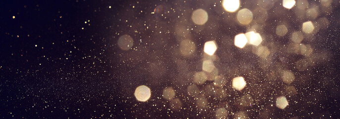 background of abstract glitter lights. gold and black. de focused. banner
