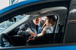 © LIGHTFIELD STUDIOS - selective focus of handsome man near attractive woman and automobile in car showroom