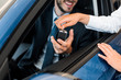 © LIGHTFIELD STUDIOS - cropped view of car dealer giving car key to bearded man